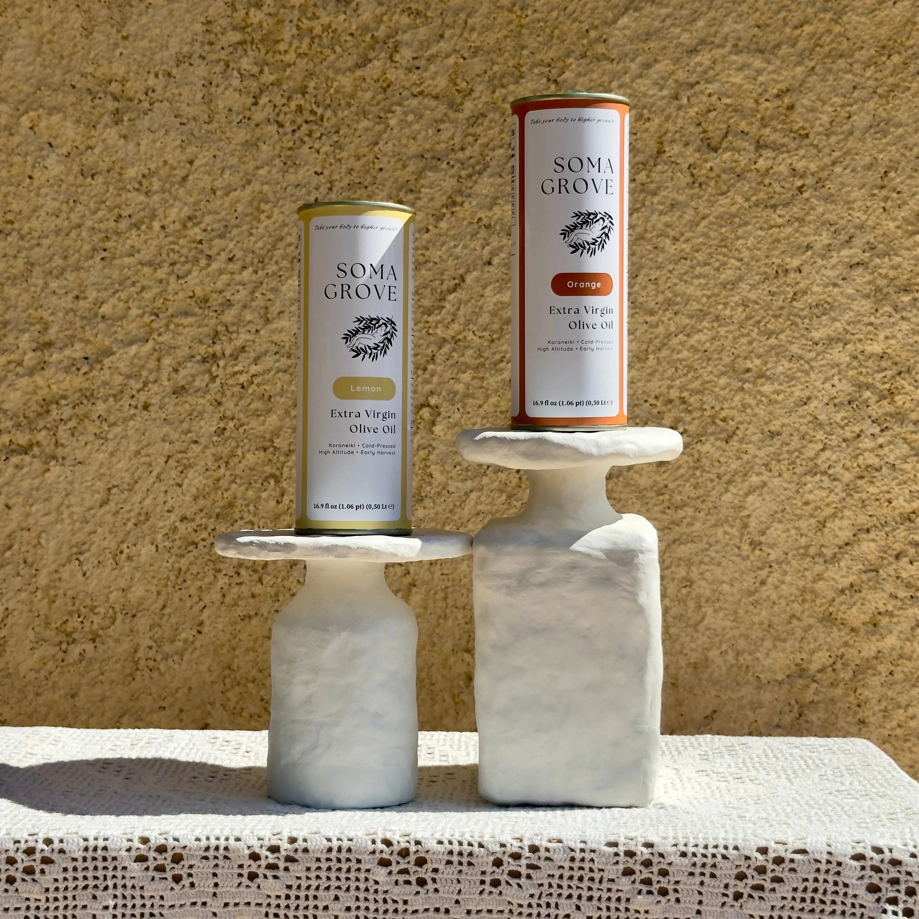 Soma Grove Citrus Olive Oil Bundle on marble stands with a rustic backdrop.