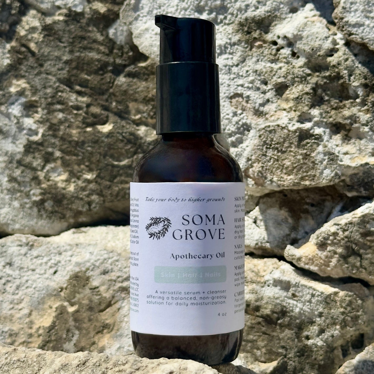 Bottle of Soma Grove apothecary oil on a stone surface