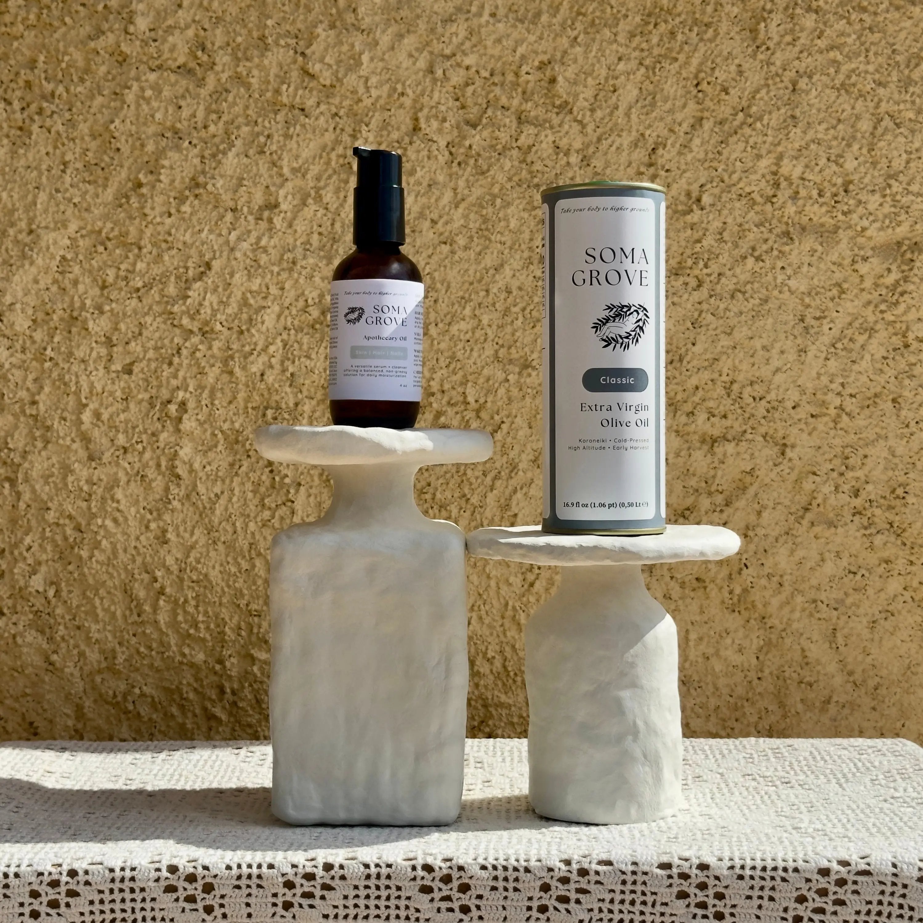 SOMA GROVE home olive oil bundle set on marble stands and a rustic backdrop.