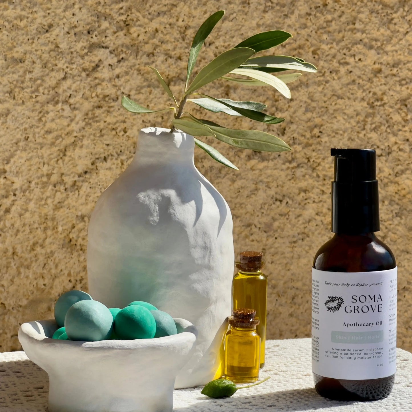Soma Grove Apothecary Oil bottle with decorative elements on a textured surface.